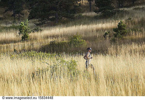Man runs through tall grass in Bear Canyon above Boulder  Colorado