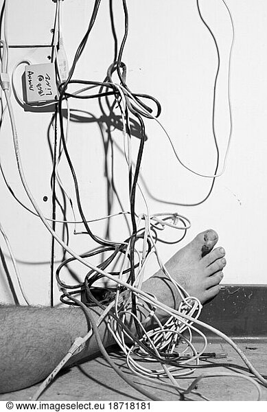 Man's right foot entangled in wires and covered in dust.
