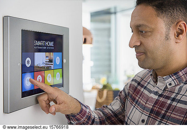 Man setting smart home navigation system alarm at touch screen