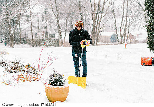 Man shoveling the driveway snow in a nor'easter in the northeast