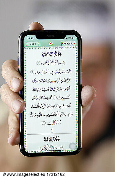 Man showing an electronic quran on a smartphone