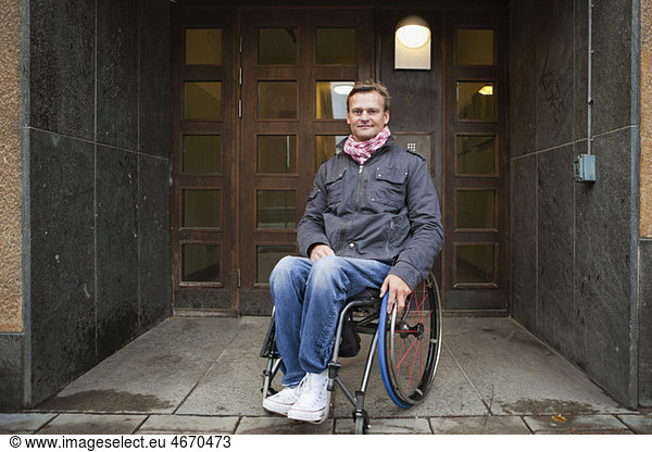 Man sitting in wheelchair outside doors