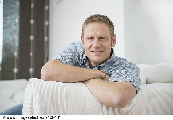 Man sitting on sofa  smiling