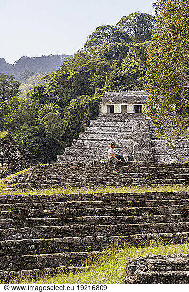 Man sitting on steps at Mayan ruins