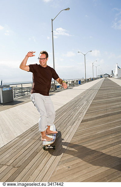 Man skateboarding on boardwalk