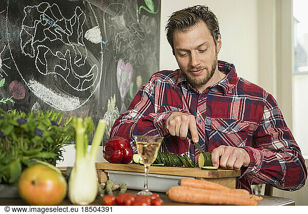 Man slicing vegetables on chopping board  Munich  Bavaria  Germany