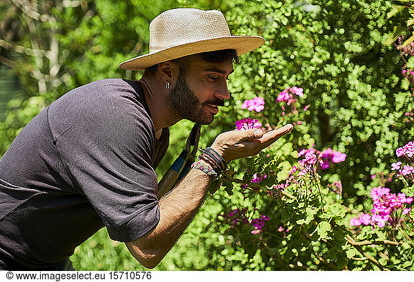 Man smelling flowers in garden