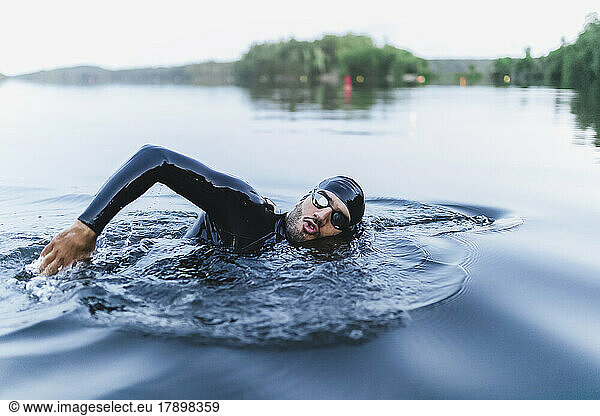 Man splashing water swimming in lake