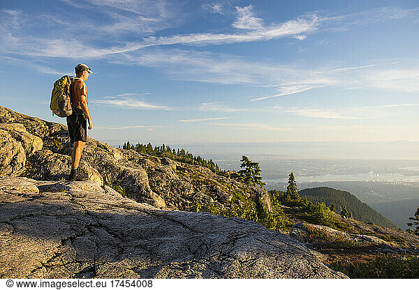 Man stands on Seymour Mountain looking down on Vancouver.