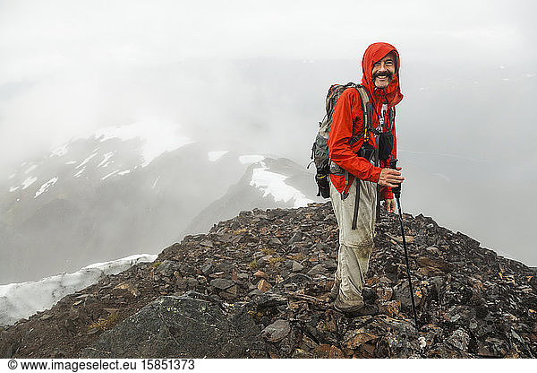 Man stands on summit of Cooper Mountain  Kenai Peninsula  Alaska