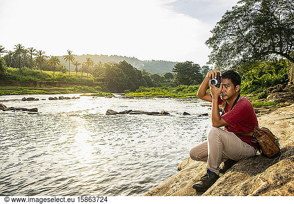 Man taking picture on his analog range finder camera in Pinnawala
