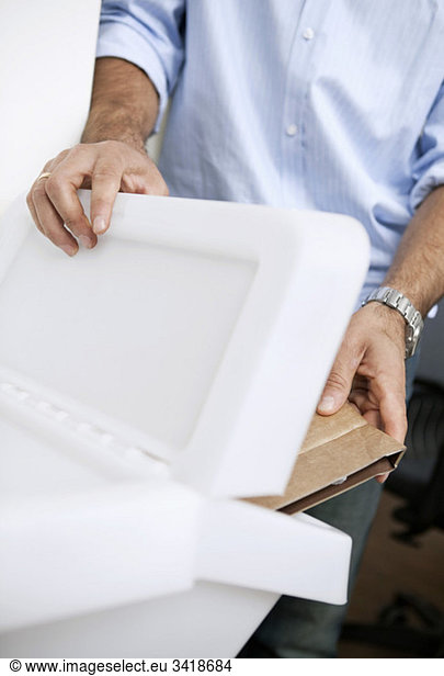Man tossing cardboard in a box