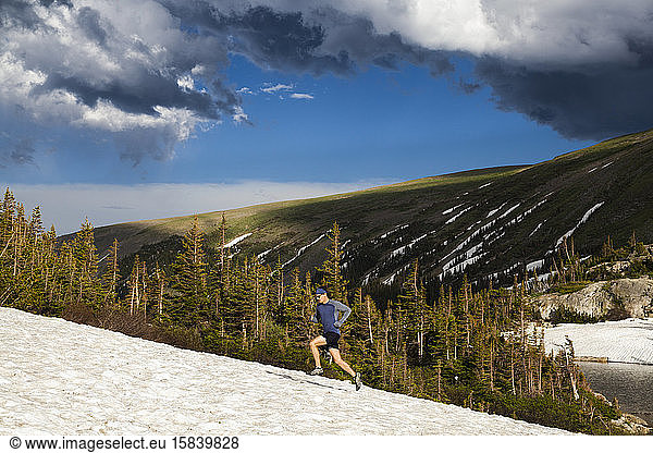 Man trail runs on snow in Indian Peaks Wilderness  Colorado