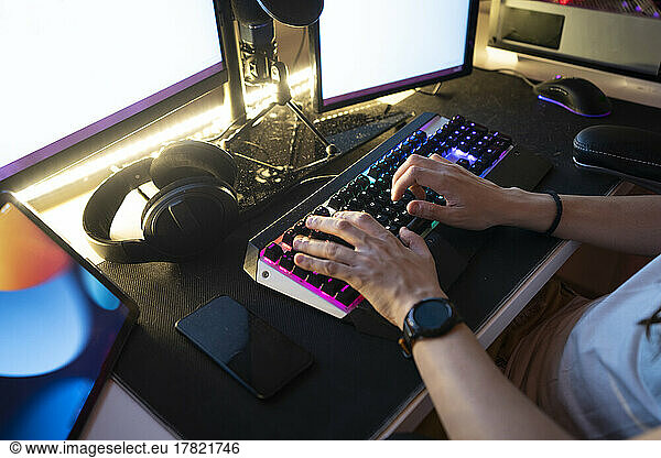 Man typing on keyboard sitting in front of desktop PC