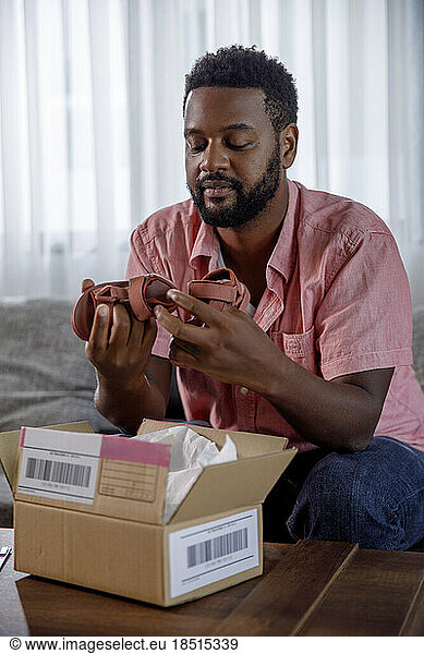 Man unboxing new shoes at home