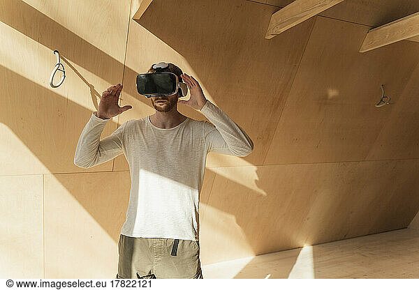 Man using 3d glasses to visualise home interior at of wooden eco house