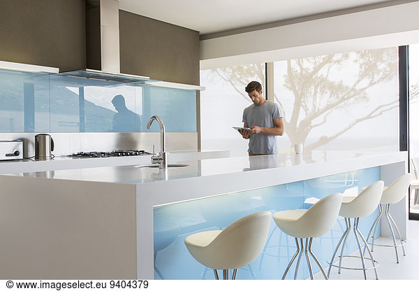 Man using digital tablet in modern kitchen