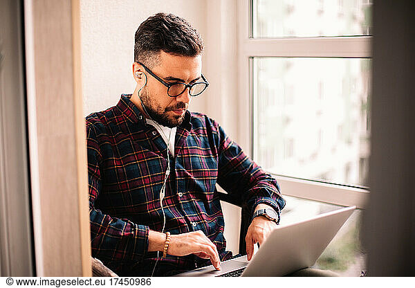 Man using laptop computer while working at home
