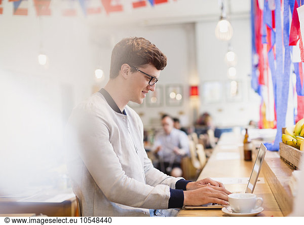 Man using laptop in cafe