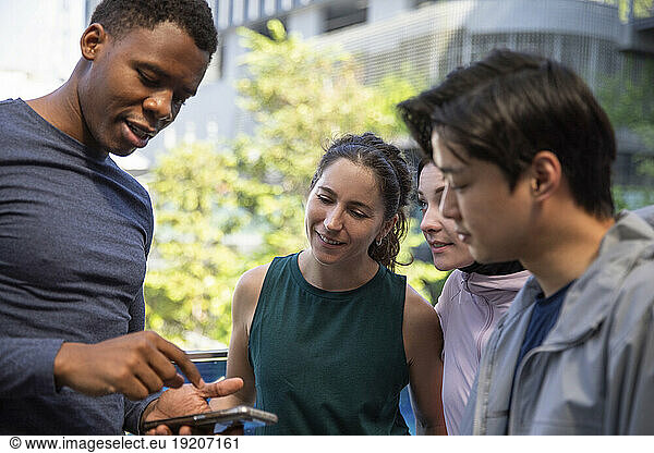 Man using mobile phone and talking to friends