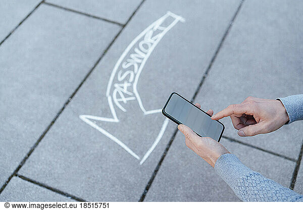 Man using smart phone with text arrow on footpath