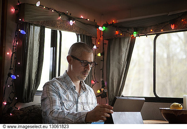 Man using tablet while sitting in camper van