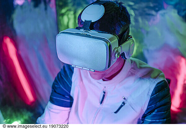 Man using virtual reality simulators in neon lights