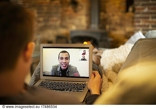 Man video conferencing with colleagues on laptop screen