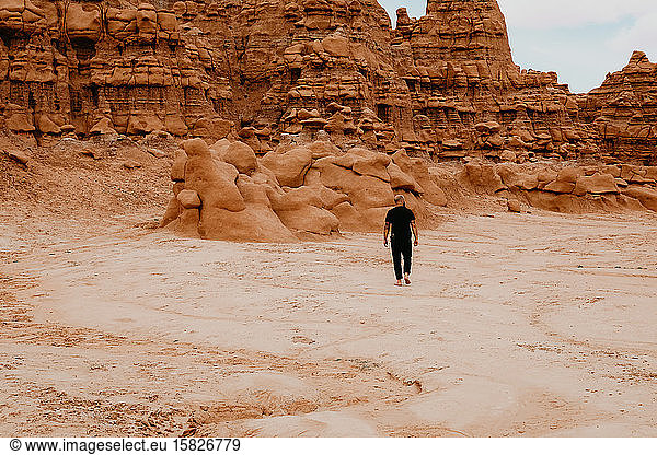 Man walking alone among hoodoo rocks in Goblin Valley