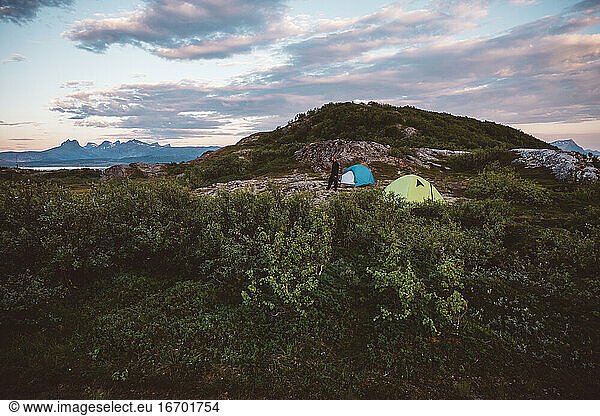 Man walking in a camp site set in a mountain top