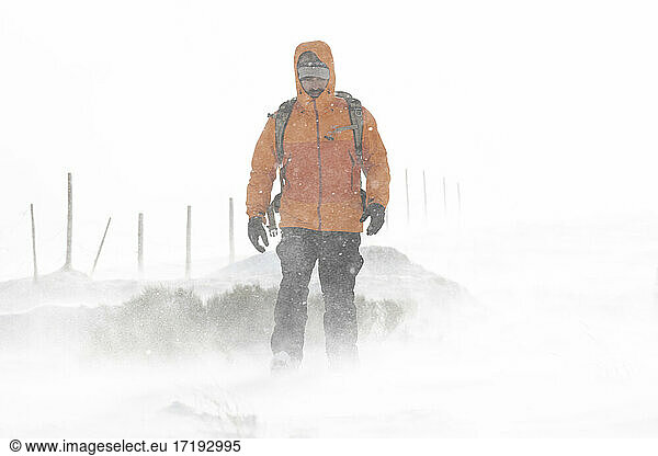 Man walking in the middle of a snowstorm