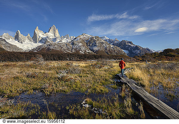 Man walking on boardwalk in front of Mount Fitz Roy in Autumn  El Chalten  Patagonia  Argentina