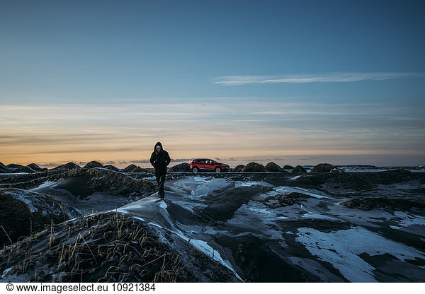 Man walking on icy mounds in remote landscape  Hofn  Iceland