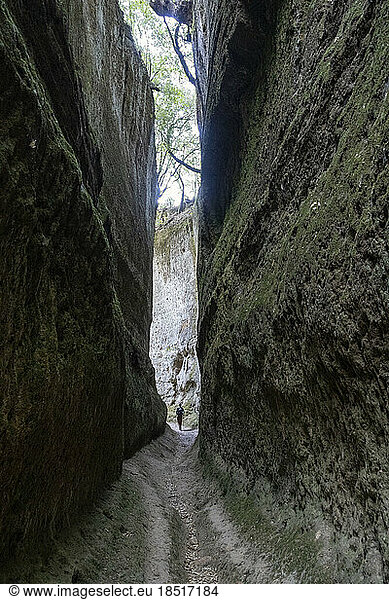 Man walking on narrow pathway amidst rocks  Tuscany  Italy