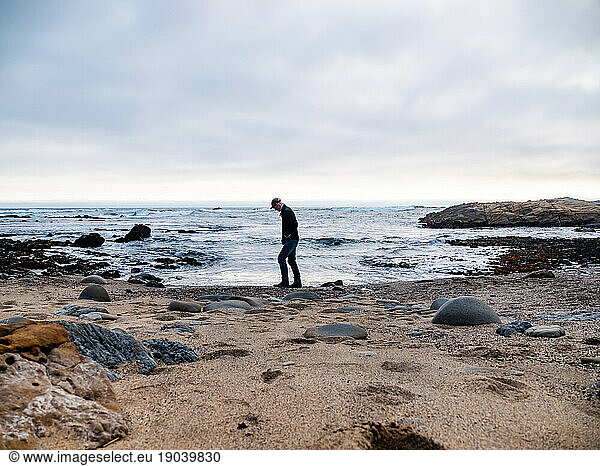 Man walking on small rocky beach