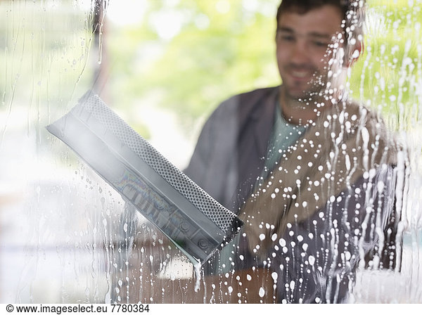 Man washing windows with squeegee