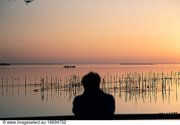 Man watching the sunset at Valencia's Albufera against the light