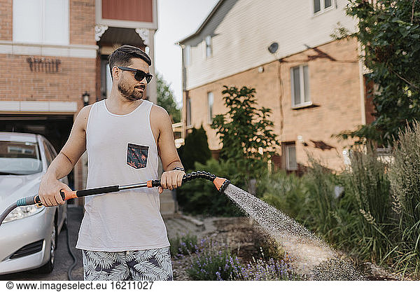 Man watering plants in garden