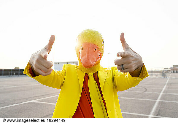Man wearing duck mask gesturing in parking lot