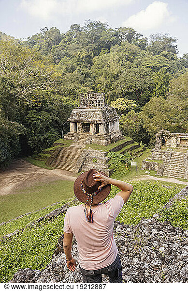 Man wearing hat looking at Mayan old ruins