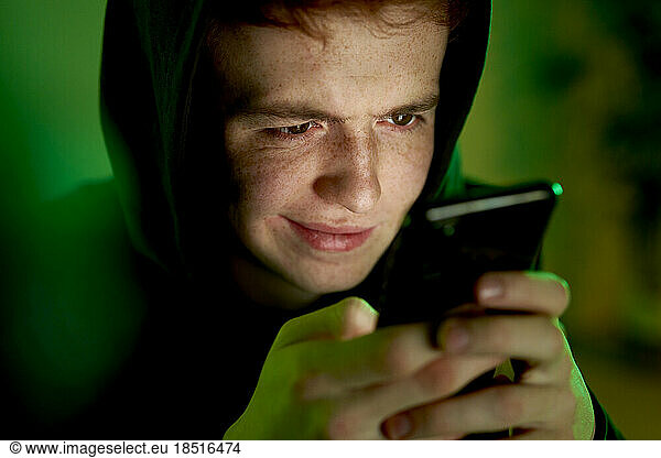 Man wearing hoodie using smart phone