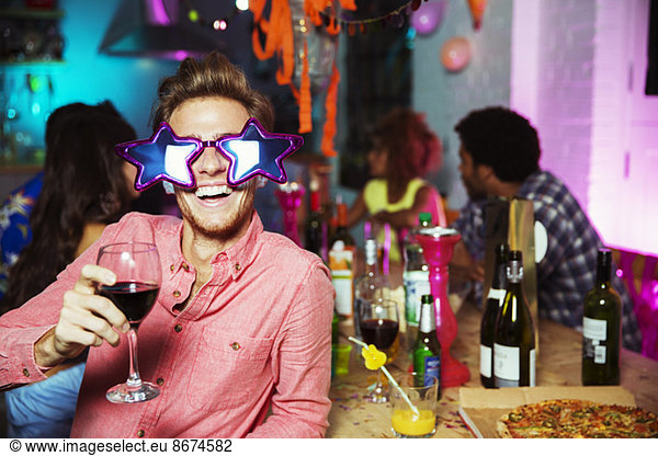 Man wearing oversized sunglasses at party