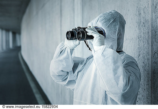 Man wearing protective clothing looking through binoculars