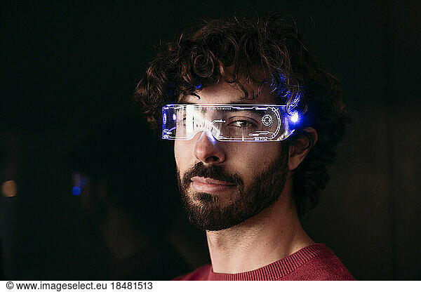 Man wearing smart eyeglasses against black background