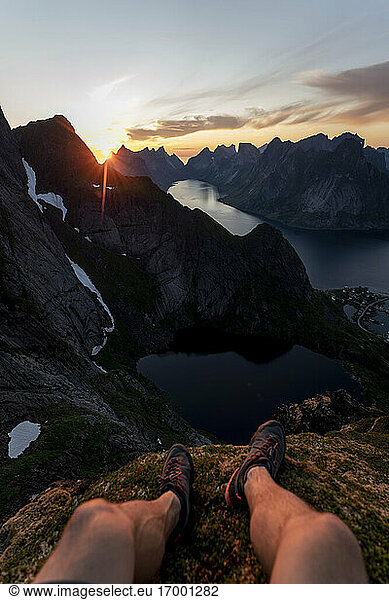 Man wearing sports shoe sitting on mountain at Reinebringen. Lofoten  Norway