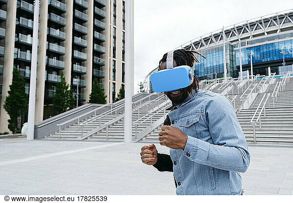Man wearing virtual reality headset in front of building
