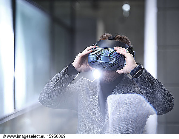 Man wearing VR glasses and headset in modern office