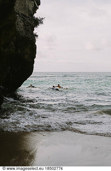 Man with a surfboard goes to the Uluwatu surf spot.