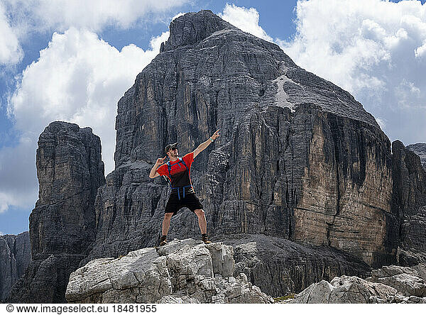 Man with arm raised standing at Cima Pisciadu  Dolomites  Italy