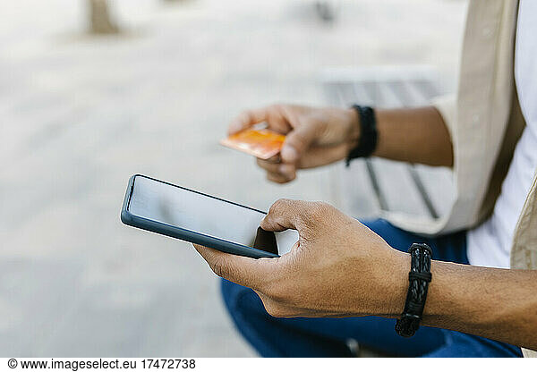 Man with credit card doing online shopping through smart phone
